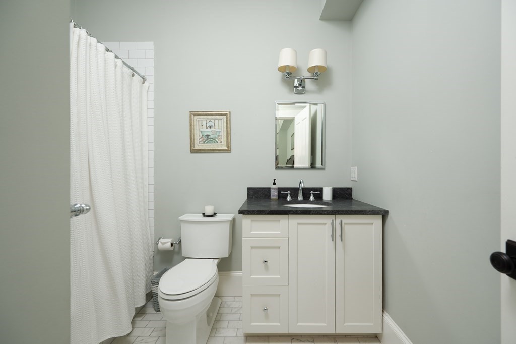 5 Dwight Street, Unit 1 Boston, MA 02118 - Photo 17 of 22 a bathroom with a toilet sink and mirror