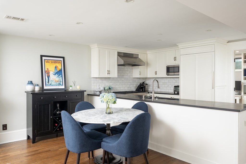 5 Dwight Street, Unit 1 Boston, MA 02118 - Photo 8 of 22 a kitchen with a dining table chairs and white cabinets