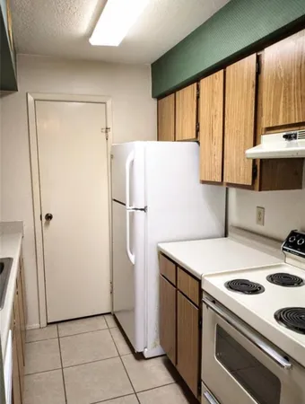 a kitchen with a refrigerator a stove top oven a sink and a refrigerator