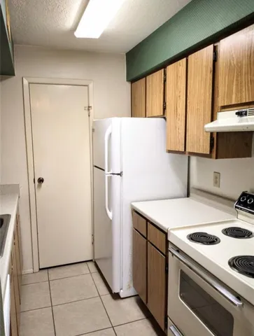 a kitchen with a refrigerator a stove top oven a sink and a refrigerator