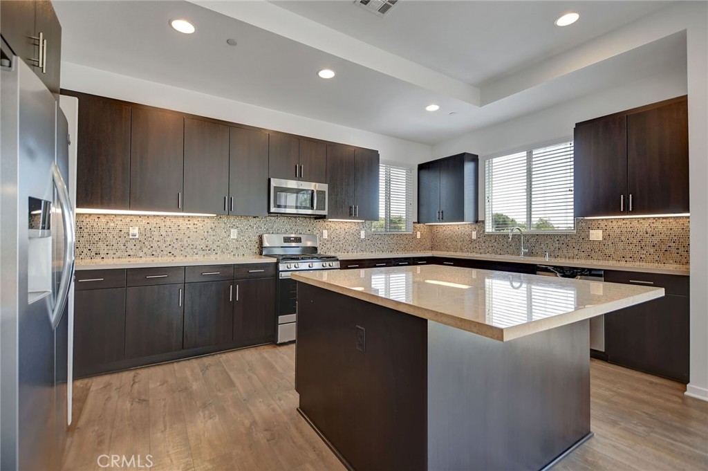 711 Brooklyn Drive Brea, CA 92821 - Photo 13 of 30 a kitchen with kitchen island granite countertop a sink stove and refrigerator
