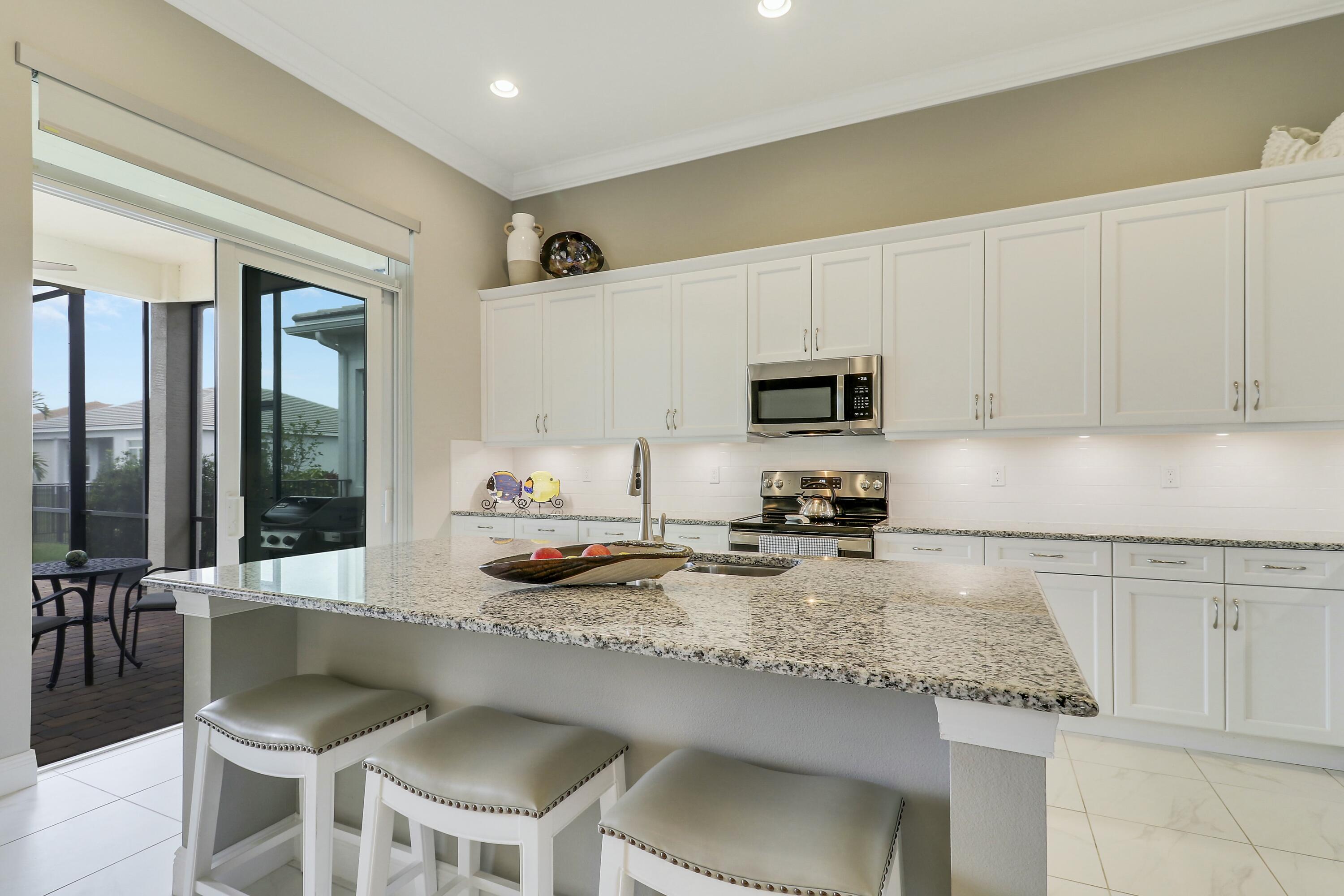 9182 Southwest Pepoli Way Port St. Lucie, FL 34987 - Photo 16 of 80 a kitchen with a stove a sink and a refrigerator