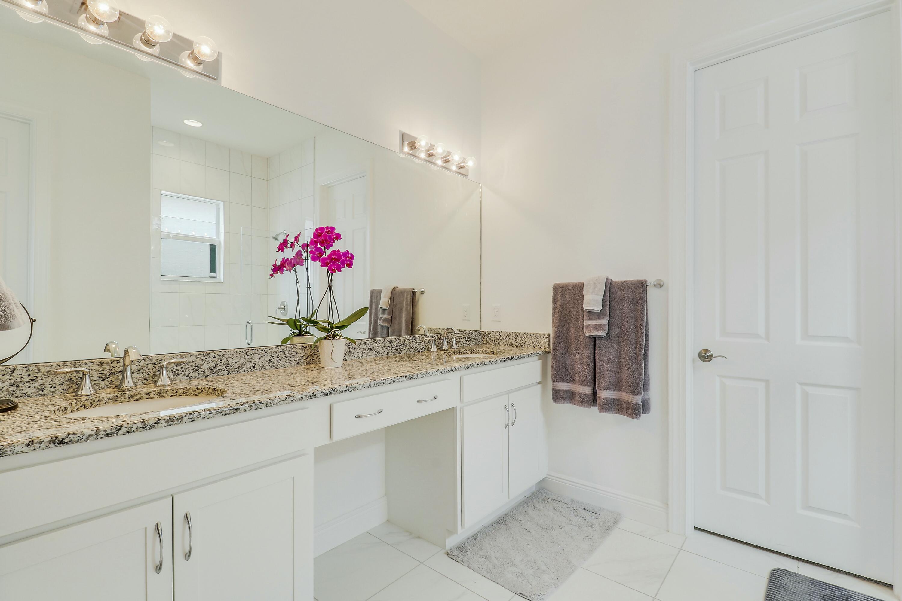 9182 Southwest Pepoli Way Port St. Lucie, FL 34987 - Photo 24 of 80 a bathroom with a granite countertop sink and a mirror