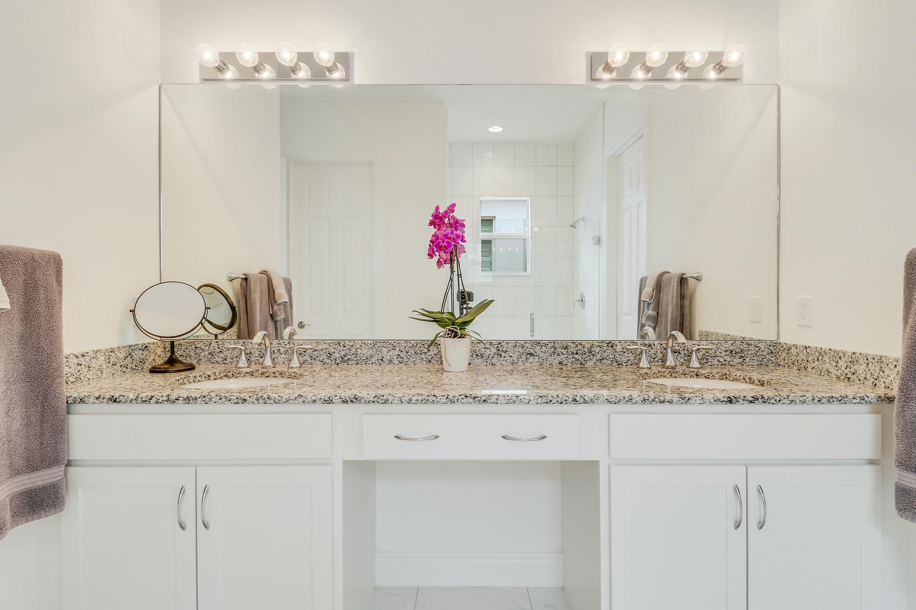 9182 Southwest Pepoli Way Port St. Lucie, FL 34987 - Photo 25 of 80 a bathroom with a granite countertop sink and a mirror