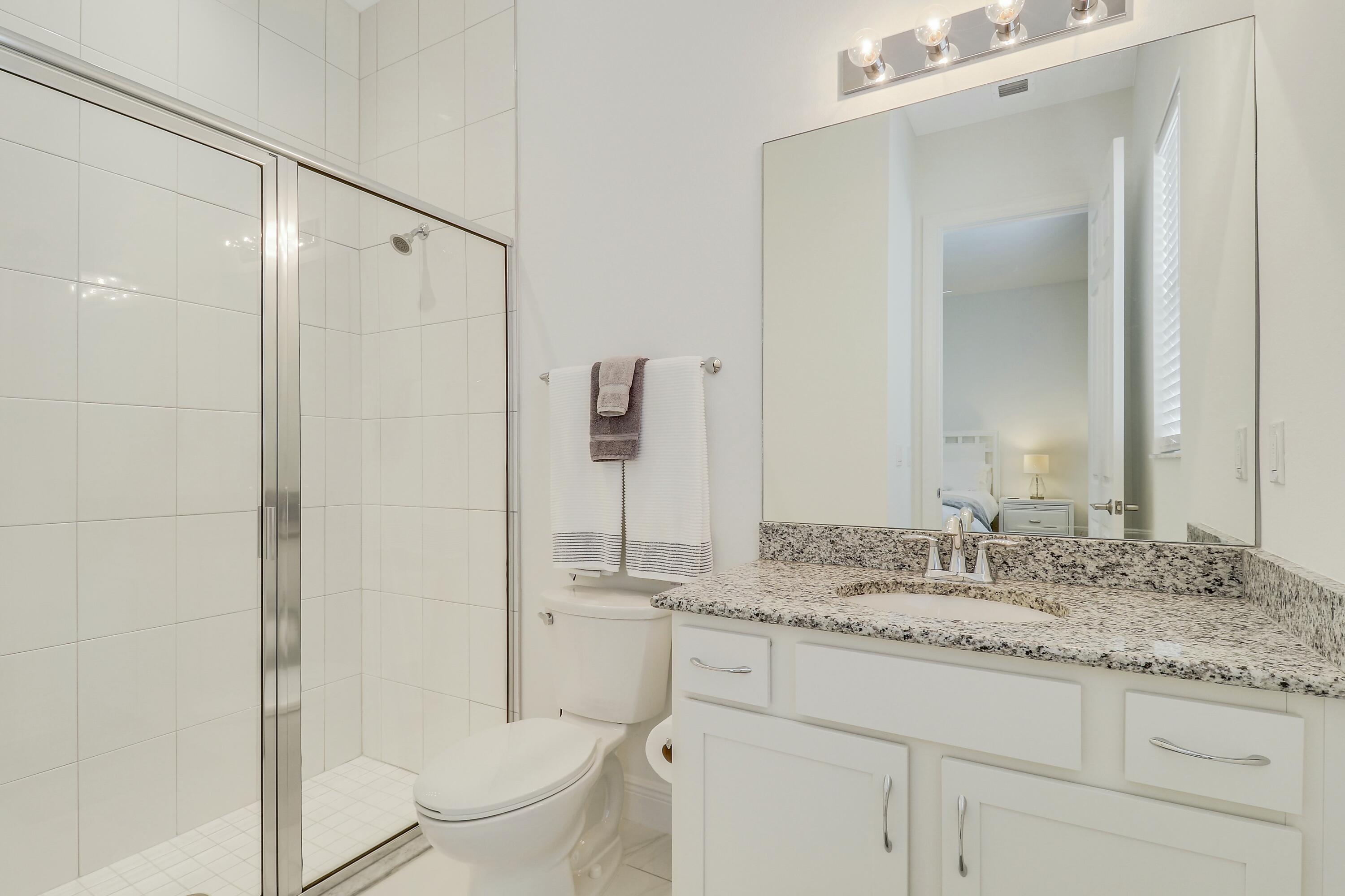 9182 Southwest Pepoli Way Port St. Lucie, FL 34987 - Photo 33 of 80 a bathroom with a granite countertop sink toilet and shower