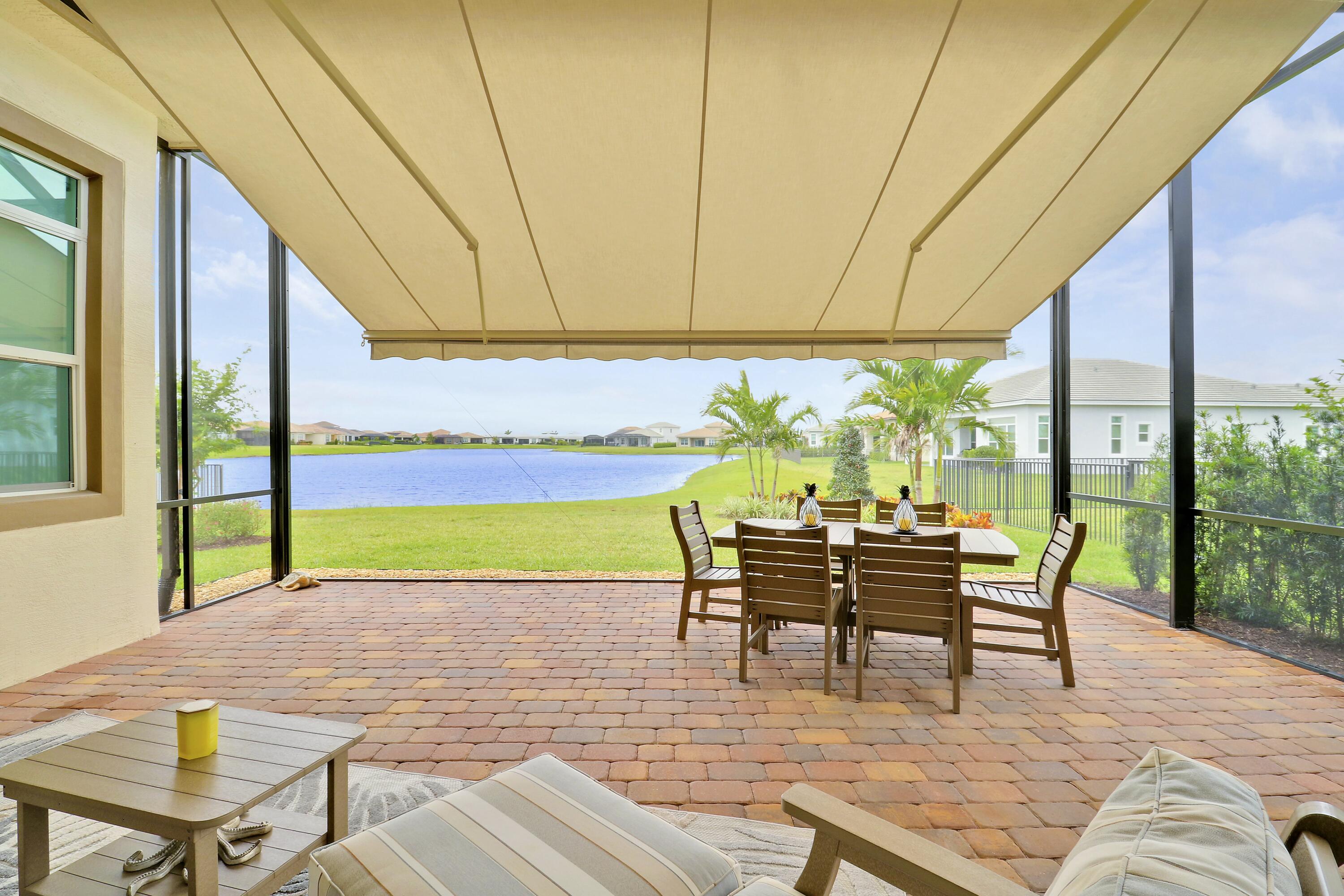 9182 Southwest Pepoli Way Port St. Lucie, FL 34987 - Photo 39 of 80 a dining room with furniture and a floor to ceiling window
