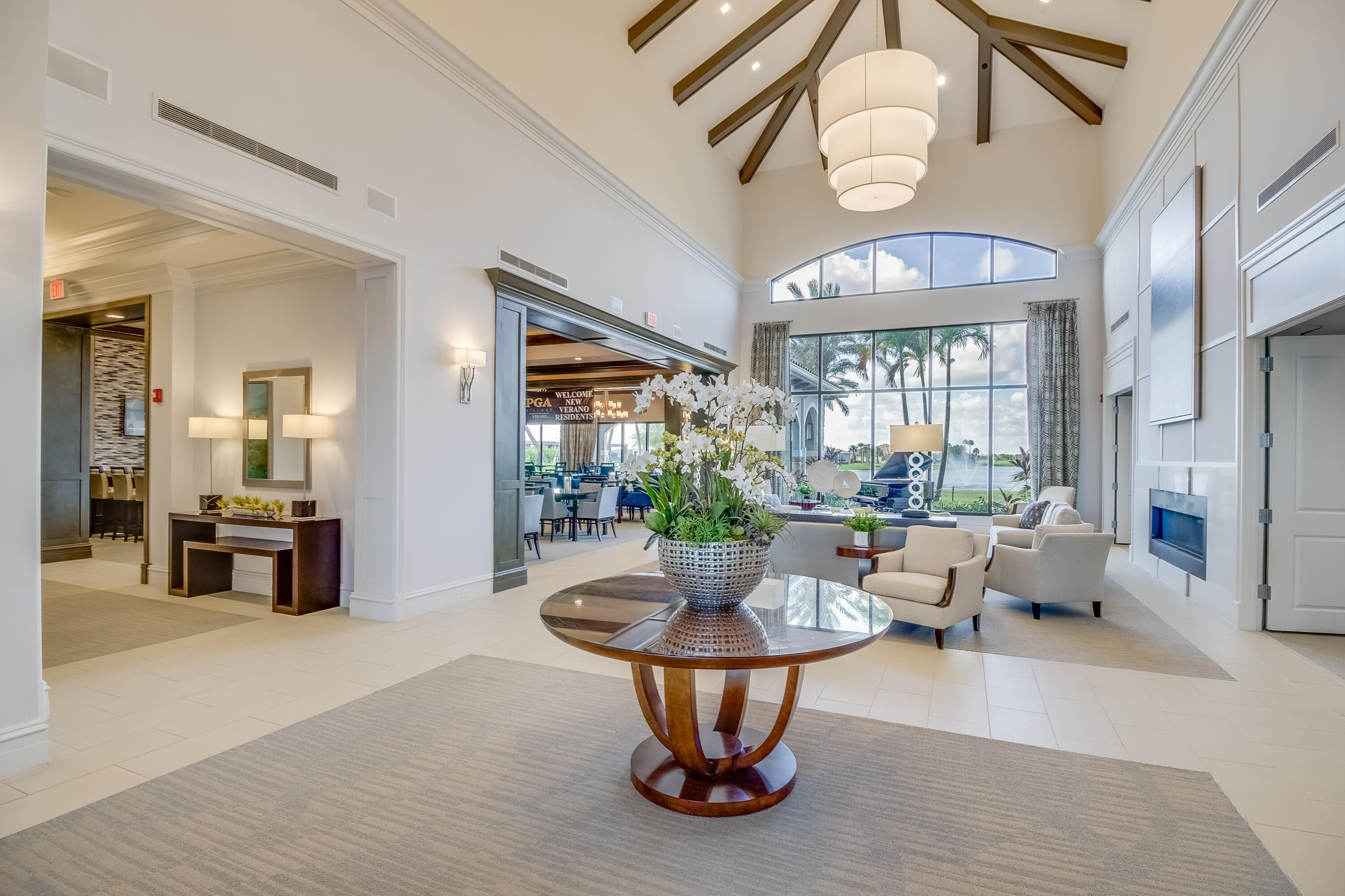 9182 Southwest Pepoli Way Port St. Lucie, FL 34987 - Photo 54 of 80 a living room with furniture a chandelier and a dining table with wooden floor