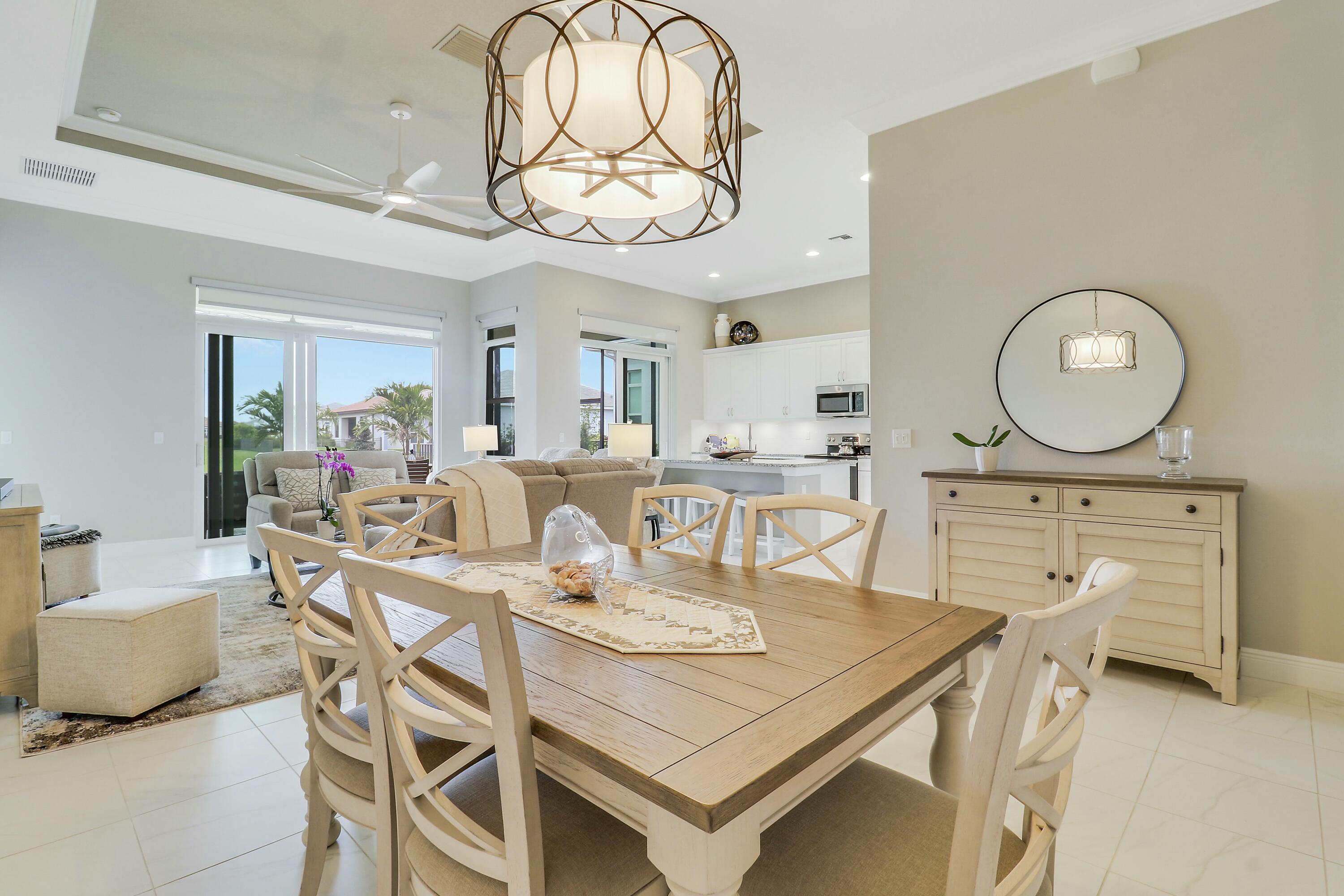 9182 Southwest Pepoli Way Port St. Lucie, FL 34987 - Photo 10 of 80 a view of a dining room with furniture a chandelier and wooden floor
