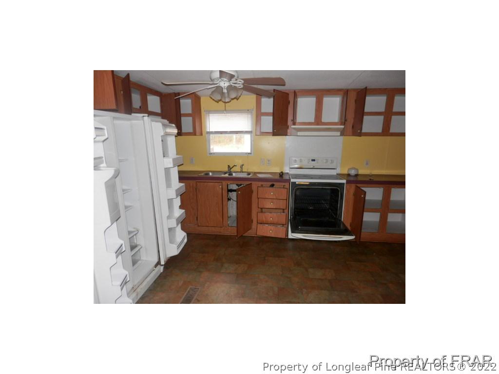 833 Fred Hall Road Stedman, NC 28391 - Photo 5 of 14 a open kitchen with granite countertop a stove and a microwave
