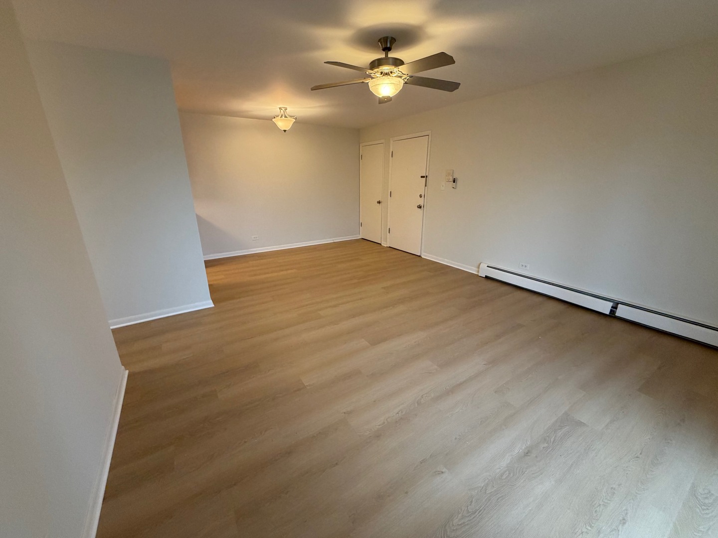 84 West Belvidere Road, Unit 203 Grayslake, IL 60030 - Photo 11 of 15 an empty room with a chandelier fan and wooden floor