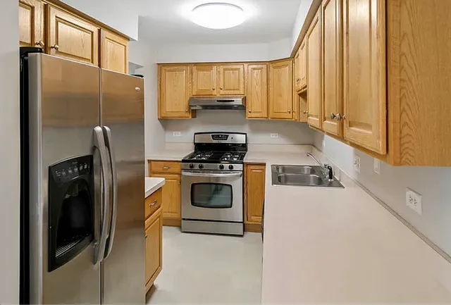 a kitchen with a refrigerator a stove and a window
