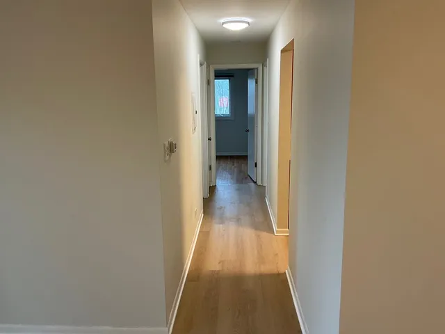 a view of a hallway with wooden floor