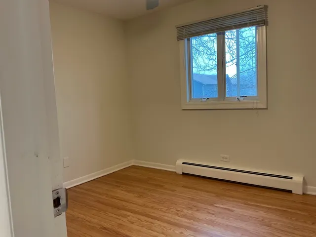 a view of a room with wooden floor and a window