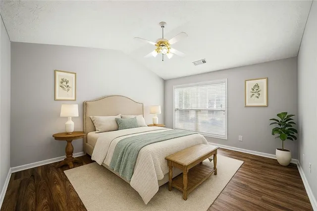 a bedroom with a bed lamp and a potted plant