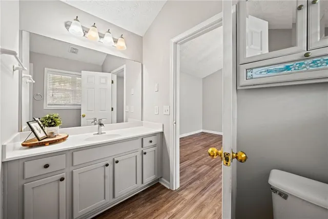 a bathroom with a granite countertop sink mirror and toilet