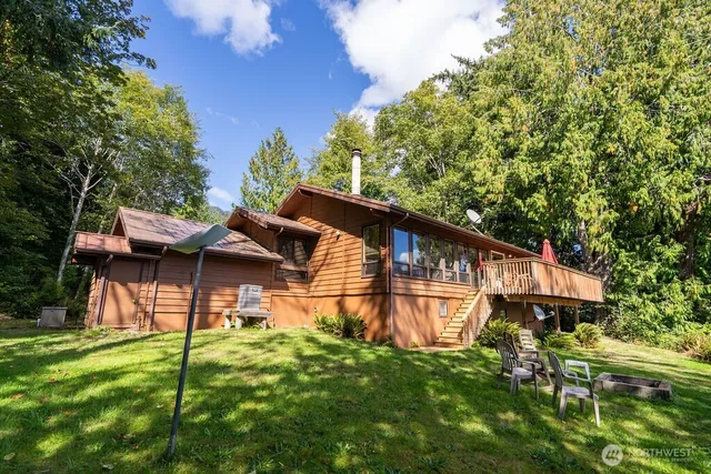 a backyard of a house with table and chairs under an umbrella