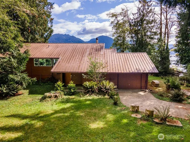 a backyard of a house with table and chairs under an umbrella