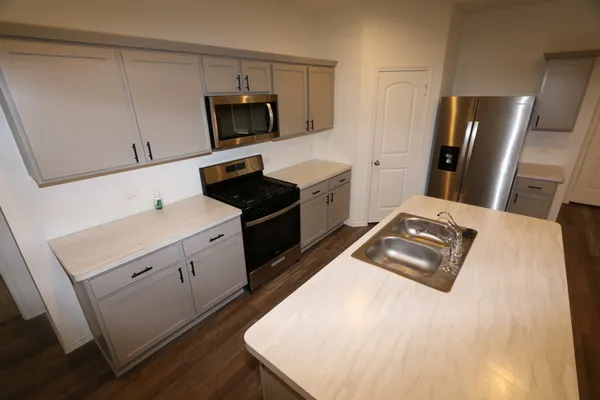a kitchen with a stove refrigerator and microwave