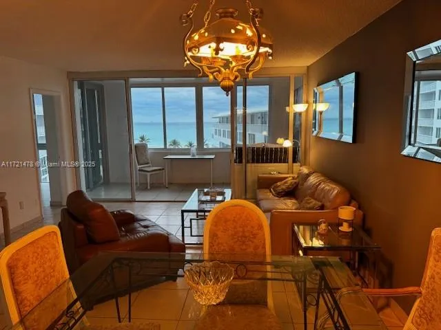 a living room with couches chandelier furniture and a large window