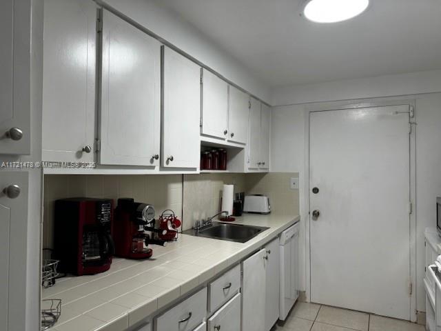 5401 Collins Avenue, Unit 430 Miami Beach, FL 33140 - Photo 27 of 52 a kitchen with a sink and cabinets