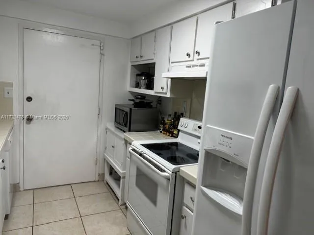 a kitchen with white cabinets and white appliances