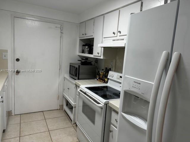 5401 Collins Avenue, Unit 430 Miami Beach, FL 33140 - Photo 28 of 52 a kitchen with white cabinets and white appliances