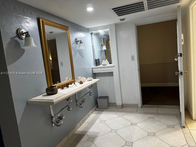 5401 Collins Avenue, Unit 430 Miami Beach, FL 33140 - Photo 46 of 52 a bathroom with a sink a toilet and mirror