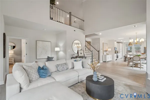 a living room with furniture a large mirror and a chandelier
