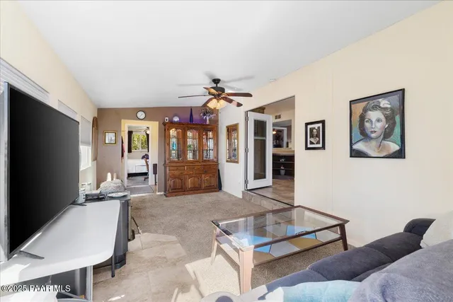 a living room with furniture a large window and a flat screen tv