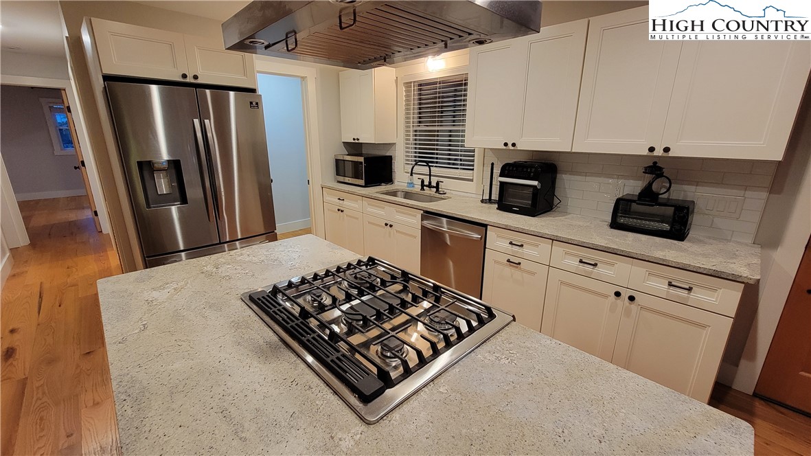 526 Hidden Valley Circle Boone, NC 28607 - Photo 9 of 29 a kitchen with stainless steel appliances granite countertop a sink stove refrigerator and cabinets
