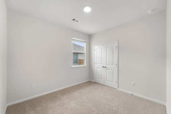 an empty room with windows and closet