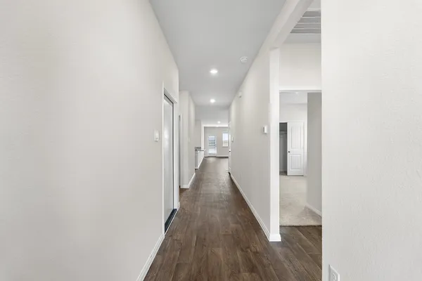 a view of a hallway with wooden floor
