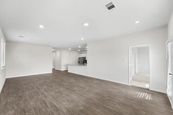 a view of a big room with wooden floor and windows