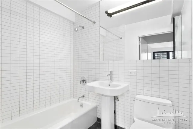 a bathroom with a sink a toilet and bathtub
