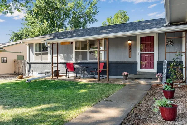 a view of house with yard and outdoor seating