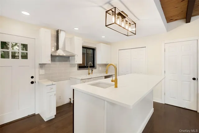 a kitchen with stainless steel appliances a sink a stove a refrigerator cabinets and living room view