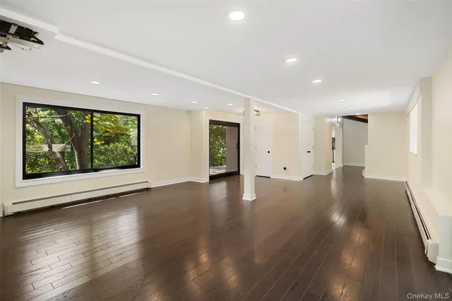 a view of empty room with wooden floor and fireplace