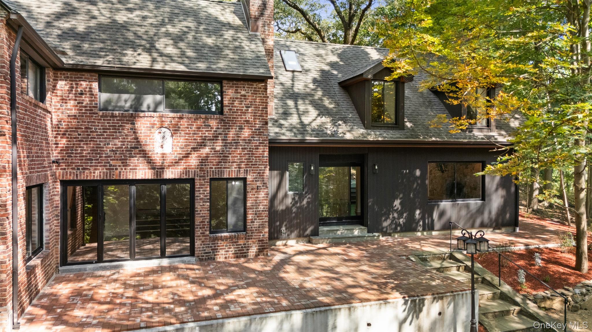27 Hardscrabble Road Briarcliff Manor, NY 10510 - Photo 36 of 43 a view of a brick house with large windows and a tree