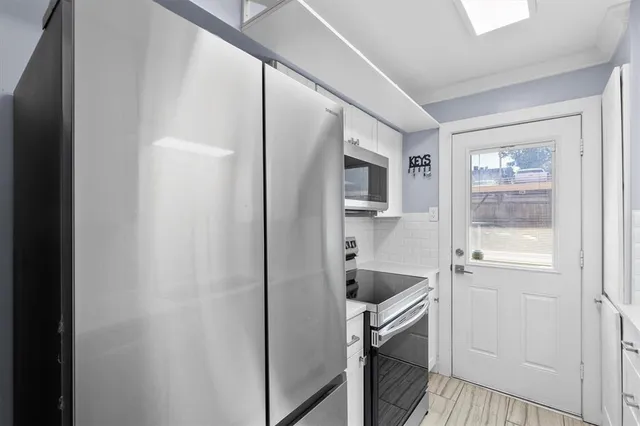 a kitchen with white cabinets and sink