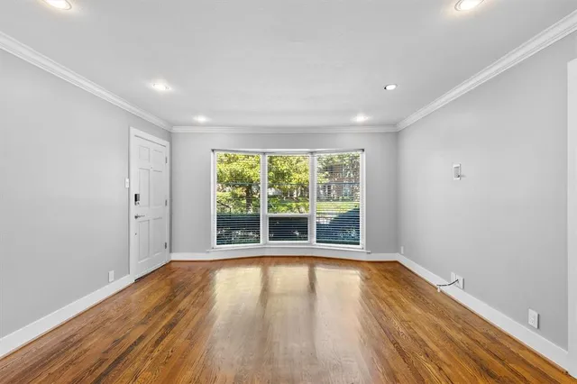 a view of a room with wooden floor and windows