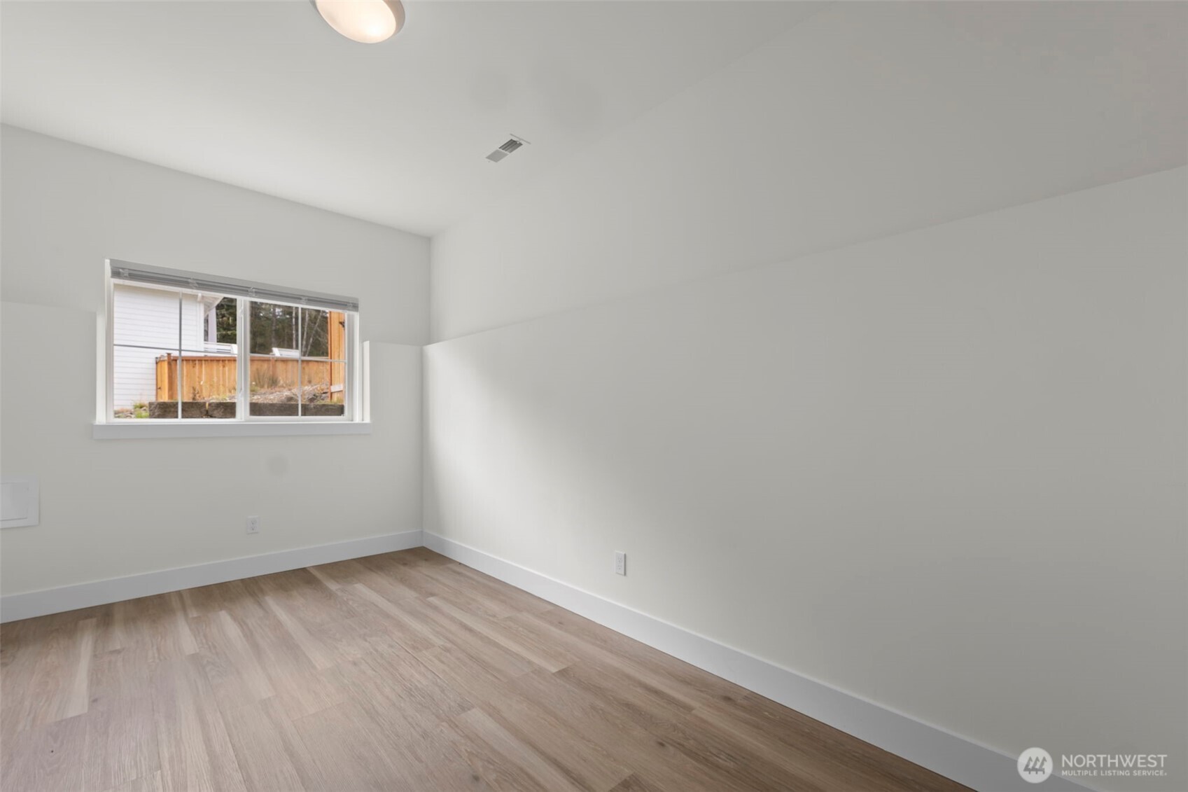 19019 Highway 3, Unit B Allyn, WA 98524 - Photo 17 of 23 a view of an empty room with wooden floor and a window