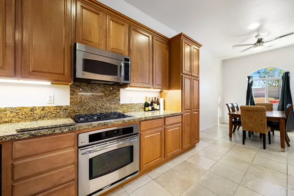 a kitchen with stainless steel appliances granite countertop a stove a sink and a microwave