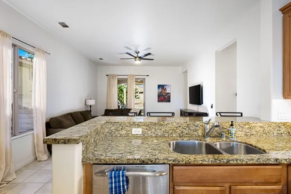 a kitchen with kitchen island granite countertop a sink and a granite counter tops