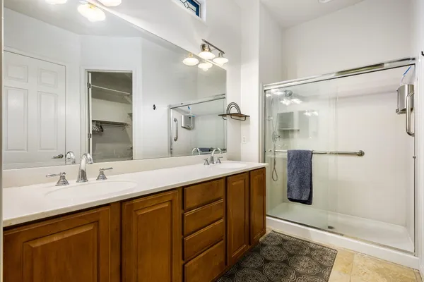 a bathroom with a double vanity sink a mirror and a shower