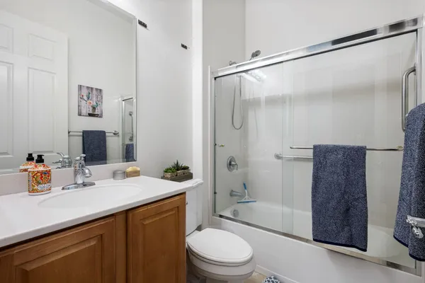 a bathroom with a sink a toilet and shower