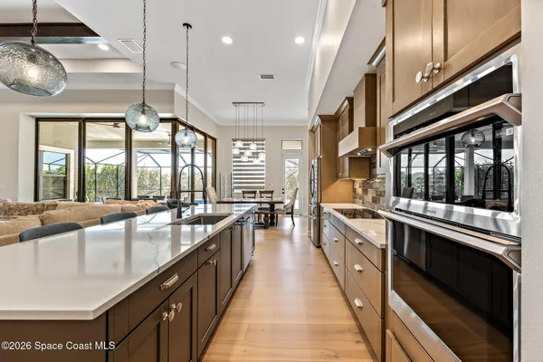 a large kitchen with stainless steel appliances kitchen island granite countertop a sink a stove and a wooden floors