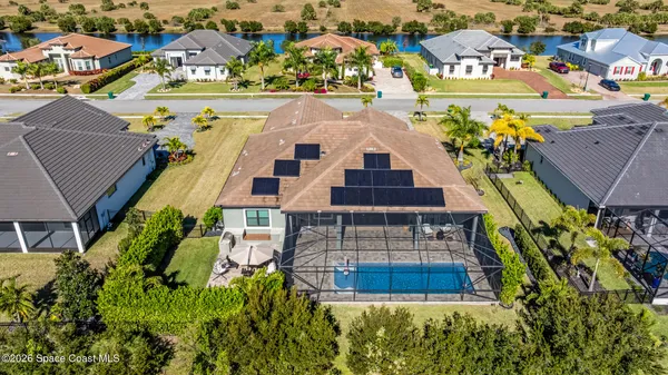 an aerial view of residential houses with outdoor space and parking