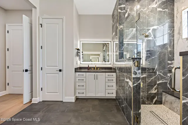 a spacious bathroom with a granite countertop sink and a mirror