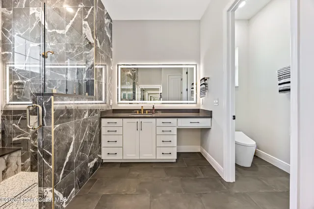 a bathroom with a double vanity sink a toilet and a tub