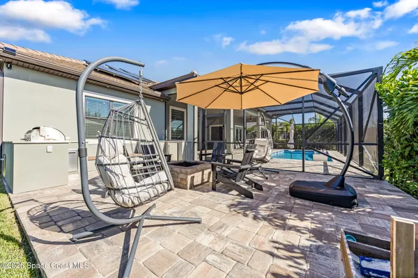 a view of a patio with a table and chairs under an umbrella